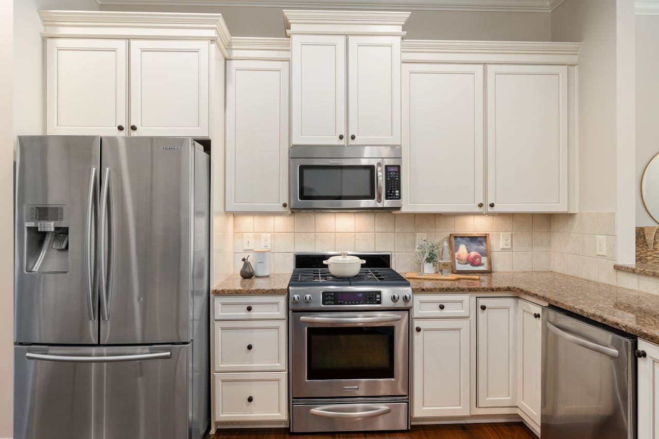 Elegant kitchen featuring stainless steel appliances and classic white cabinetry.